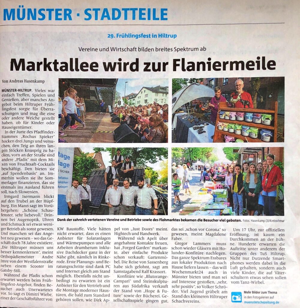 Menschen verschiedener Altersgruppen genießen ein Frühlingsfest in einer belebten Marktgasse, mit einem Stand von KW Baustoffe im Vordergrund, der Baustoffe und Informationen zu Photovoltaik präsentiert.