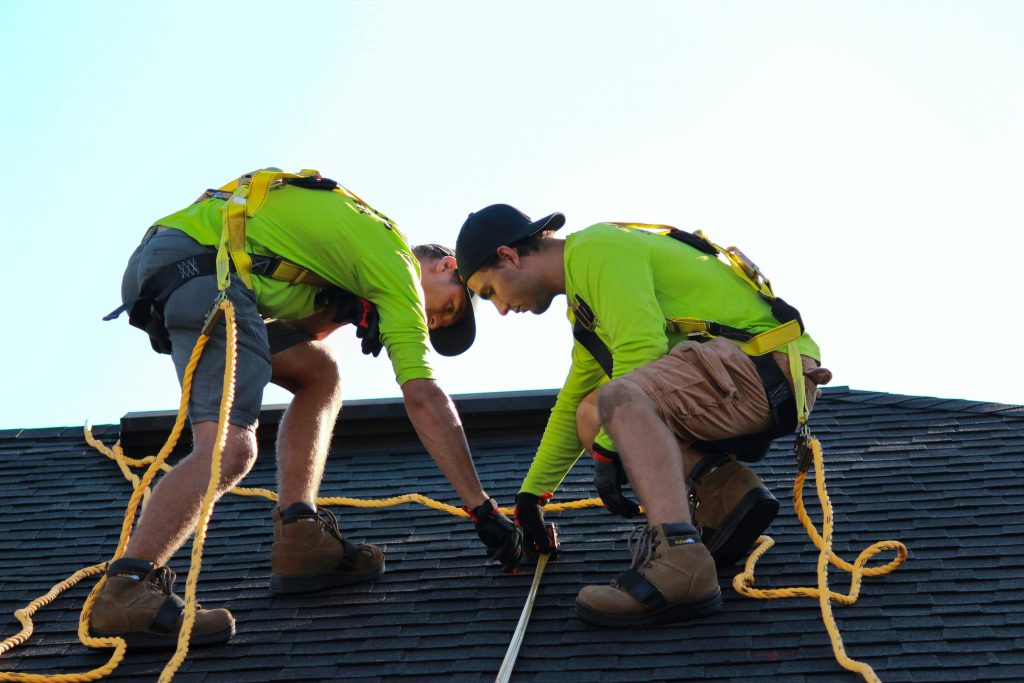 a couple of men working on a roof (Symbolbild: Photovoltaik)