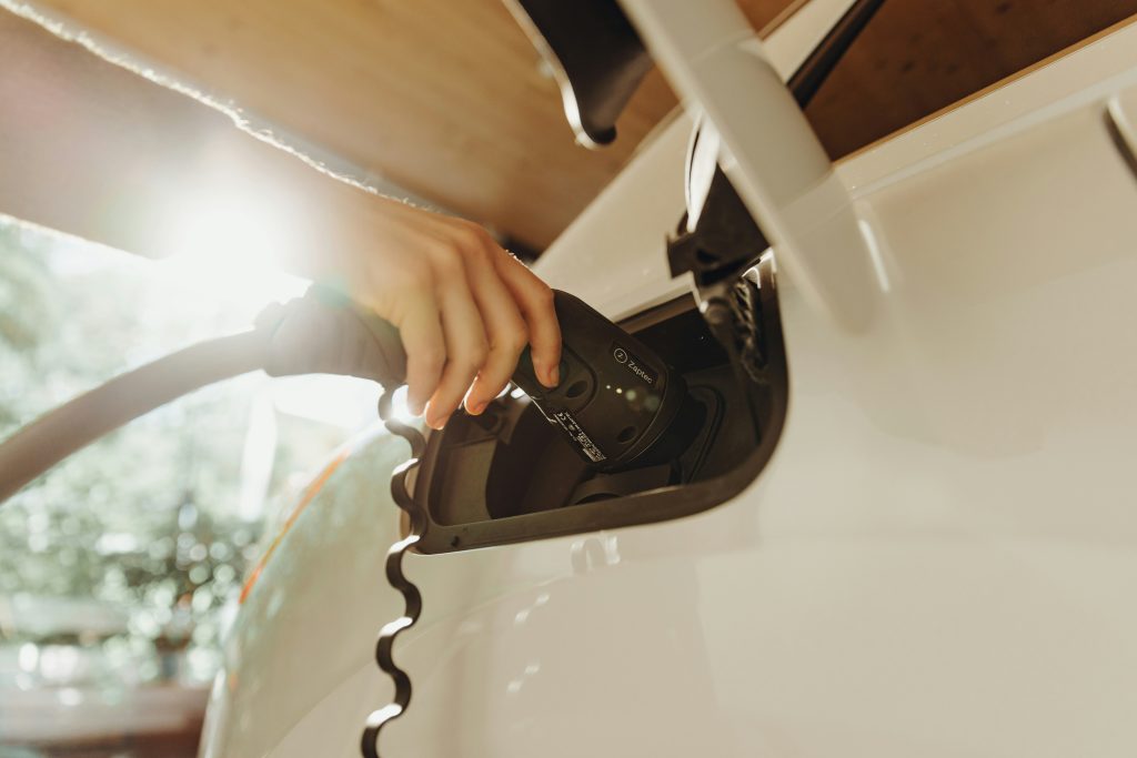 a person pumping gas into a car at a gas station (Symbolbild: Wallbox)