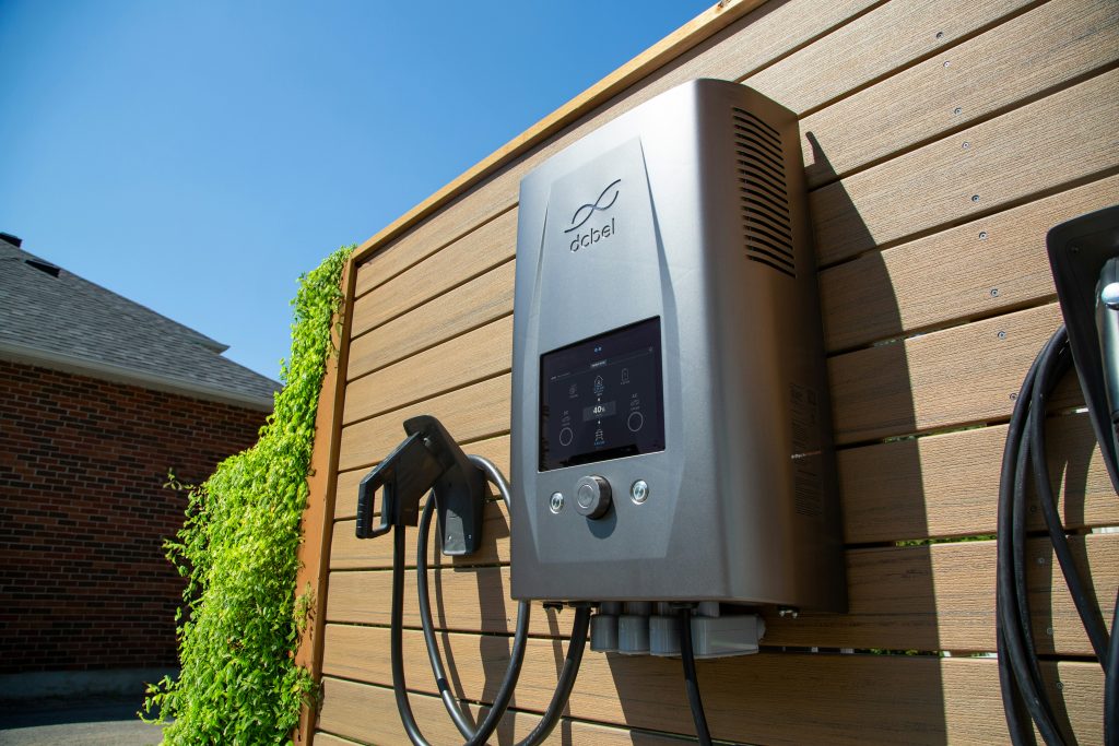 Electric car charger mounted on a wooden wall (Symbolbild: DC-gekoppelte Speicher)